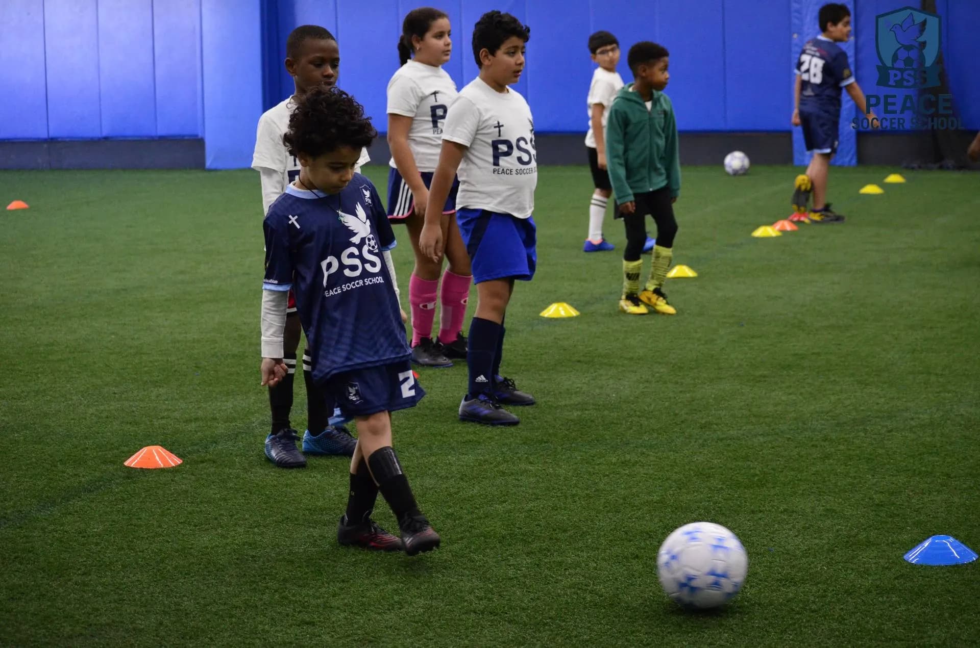 Kids running soccer drills in PSS gear at faith-based soccer academy